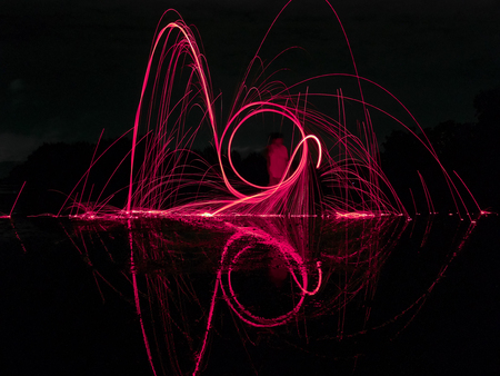 light lines of steel wool with long exposure, speed motion abstract background in the dark nightの写真素材