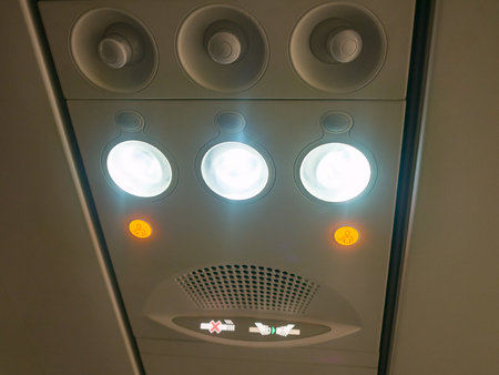 dashboard control overhead in plane cabin  for adjust air conditioning and lights switch for reading with no smoking sign and seat belt sign . orange button for call air hostess or steward to service.の写真素材