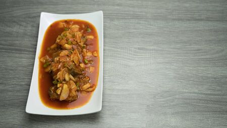 Spicy canned sardine fish salad and herbs spices chilli, lime,shallots in tomato sauce , close-up  horizontal view from above, on wooden tableの写真素材