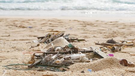 Environmental pollution. Ecological problem. Garbages, plastic, and wastes on the sandy beach of tropical sea. の写真素材