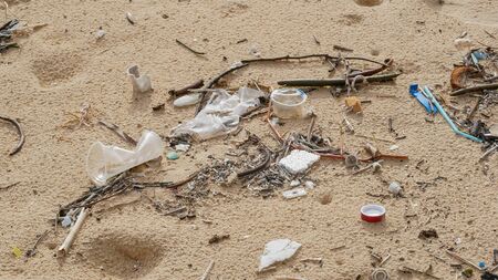 Environmental pollution. Ecological problem. Garbages, plastic, and wastes on the sandy beach of tropical sea.の写真素材