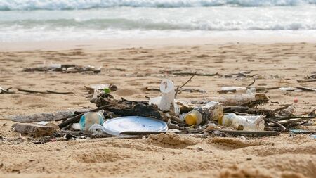 Environmental pollution. Ecological problem. Garbages, plastic, and wastes on the sandy beach of tropical sea. の写真素材