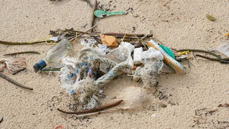 Environmental pollution. Ecological problem. Garbages, plastic, and wastes on the sandy beach of...