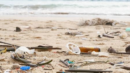 Environmental pollution. Ecological problem. Garbages, plastic, and wastes on the sandy beach of tropical sea. の写真素材