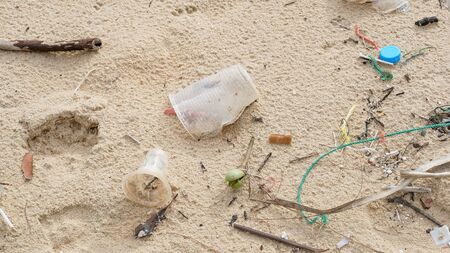 Environmental pollution. Ecological problem. Garbages, plastic, and wastes on the sandy beach of...