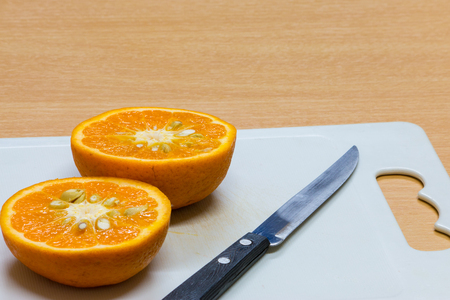 pieces of orange, a little knife cut orange to two pieces on the chopping blockの写真素材