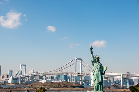 Lady liberty juxtaposed stand against Rainbow Bridge in Tokyo, Odaiba in Japanの写真素材
