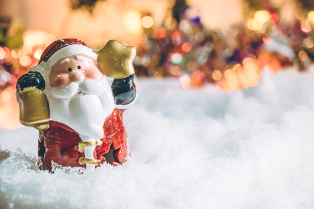 Santa claus hold the bell and star and light bulb stand in silent night, light up the hopefulness and happiness in Merry christmas and new year night.の写真素材