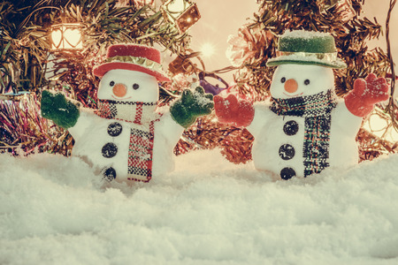 Snowman stand among pile of snow at silent night with a light bulb, light up the hopefulness and happiness in Merry christmas and happy new year night.の写真素材