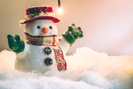 Snowman stand among pile of snow at silent night with a light bulb, light up the hopefulness and happiness in Merry christmas and happy new year night.の写真素材