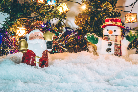 Snowman stand among pile of snow at silent night with a light bulb, light up the hopefulness and happiness in Merry christmas and happy new year night.の写真素材