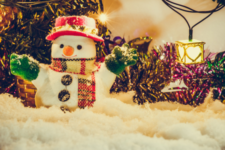 Snowman stand among pile of snow at silent night with a light bulb, light up the hopefulness and happiness in Merry christmas and happy new year night.の写真素材