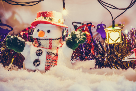 Snowman stand among pile of snow at silent night with a light bulb, light up the hopefulness and happiness in Merry christmas and happy new year night.の写真素材