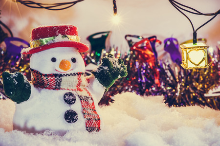 Snowman stand among pile of snow at silent night with a light bulb, light up the hopefulness and happiness in Merry christmas and happy new year night.の写真素材