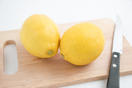 fresh lemon and knife on the chopping block, isolate backgroundの写真素材