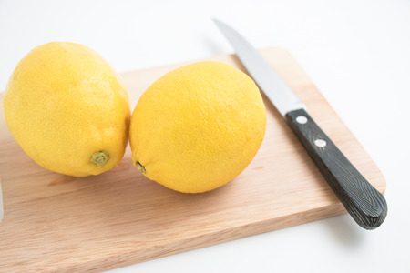 fresh lemon and knife on the chopping block, isolate backgroundの写真素材