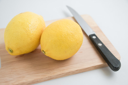 fresh lemon and knife on the chopping block, isolate backgroundの写真素材