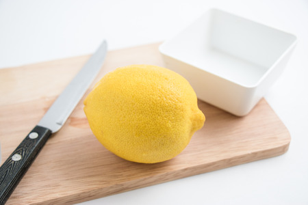 fresh lemon and knife on the chopping block, isolate backgroundの写真素材