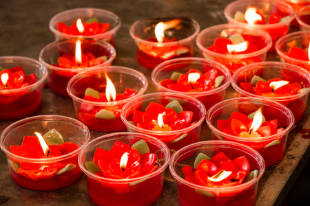 Burning red flower candle at chinese shrine for making merit in chinese new year festival. Pray for New Year,Lighting incense to Buddha.の写真素材