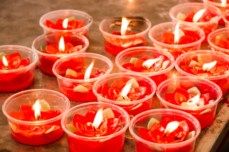 Burning red flower candle at chinese shrine for making merit in chinese new year festival. Pray for New Year,Lighting incense to Buddha.の写真素材