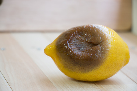 rotten lemon put on wooden table, isolate backgroundの写真素材