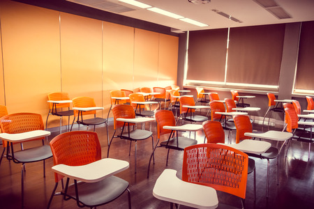 Empty classroom with orange arm chairsの写真素材
