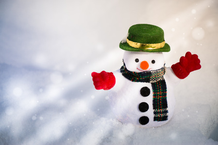 Snow man stand among pile of snow. Morning sunshine is warming in winter.の写真素材