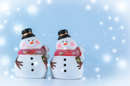 2 Snowman stand on white background. Snow flake is falling down.の写真素材