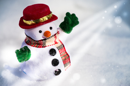 Snow man stand among pile of snow. Morning sunshine is warming in winter.の写真素材
