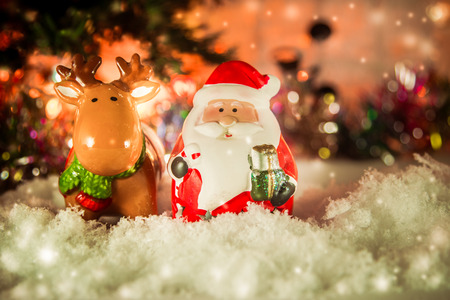 Santa claus, reindeer stand in snow and Ornament Christmas items decorate for the silent night. Merry xmas and Happy new year. Snow flake is falling down.の写真素材