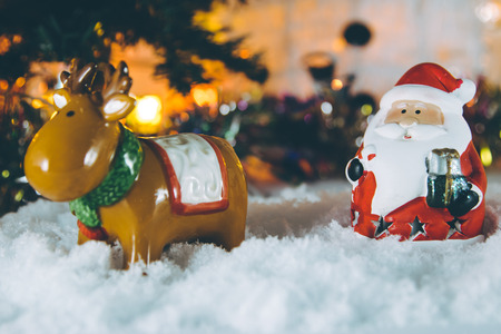 Santa claus, reindeer stand in snow and Ornament Christmas items decorate for the silent night. Merry xmas and Happy new year. Snow flake is falling down.の写真素材