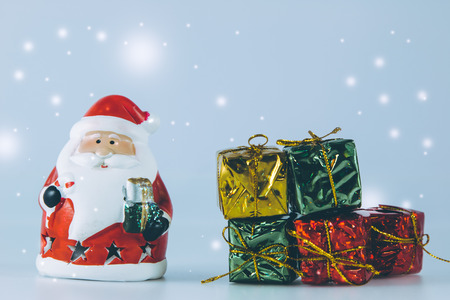 Santa claus and present box stand on white background. Snow flake is falling down. Decoration gift for Merry Christmas and happy new yearの写真素材