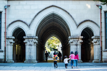 Path way at arch doors with motion of 4 chidren walk at street of arch doors, sister lead brother by the hand in Tokyo University Japanのeditorial素材
