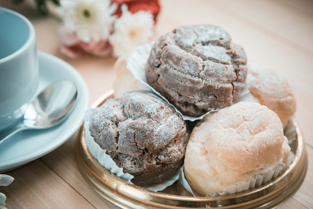 Custard and chocolate Chu cream puff on plate with cup of coffee  on wooden tableの写真素材