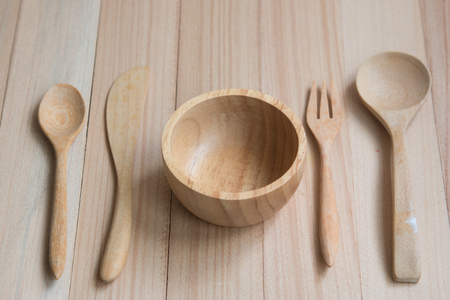 Wooden bowl, spoon, fork, and knife put on the wooden table set of kitchen ware. Wood Kitchen Utensilsの写真素材