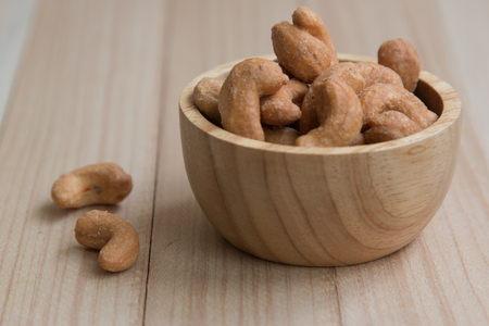 Dried salt Cashew nuts in a bowl on wooden table backgroundの写真素材