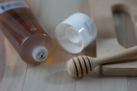 Plastic Bottle of Honey and wooden honey dipperの写真素材