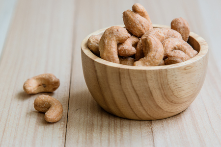 Dried salt Cashew nuts in a bowl on wooden table backgroundの写真素材