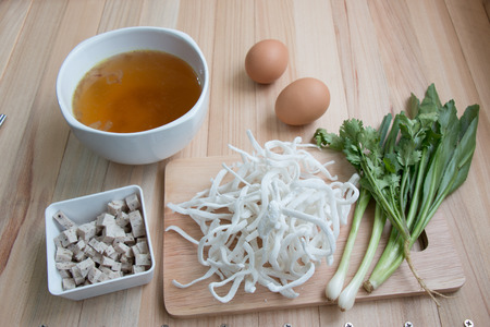 Ingredient of Pho Vietnamese noodle, original flour noodle, egg, pork sausage, and thai parsley put on chopping blockの写真素材
