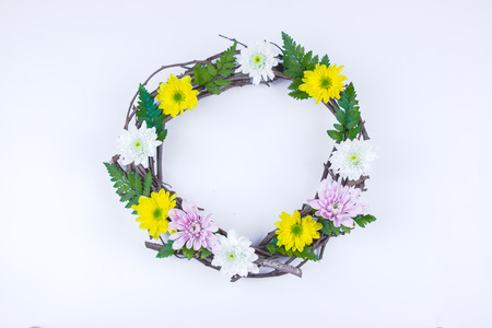 Floral and branch round crown(wreath) white daisy and green leaf. Isolated white background. summer and spring. Space for text. Flat lay, top viewの写真素材