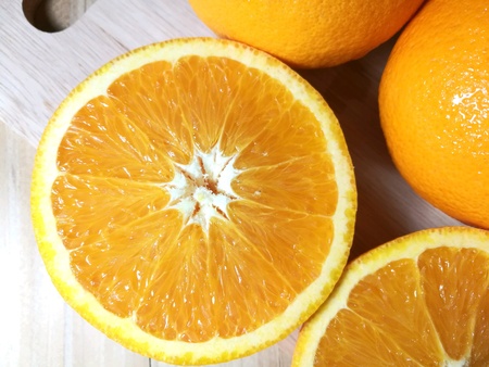 Fresh orange fruit isolated on wooden background. Orange slice.の素材