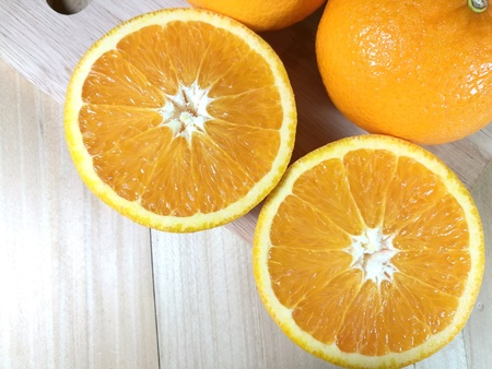 Fresh orange fruit isolated on wooden background. Orange slice.の素材