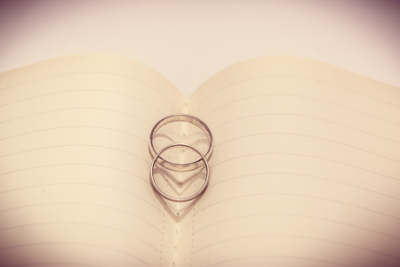 Heart shadow of Wedding Ring Put on center notebook, Valentines Day background, wedding dayの写真素材