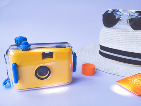 Flat lay view of summer and travel accessories. Hat, sun glasses, sunblock cream protection and camera.の写真素材