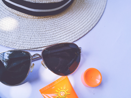 Flat lay view of summer and travel accessories. Hat, sun glasses, sunblock cream protection and camera.の写真素材
