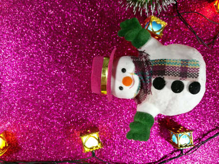 Snowman lay on glitter ponk background in holy night at merry christmas and happy new year.の素材