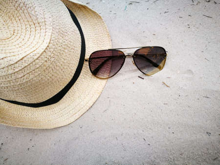 Hat and sun glasses on sand beach, item and accessories for summer vacation and holidayの写真素材