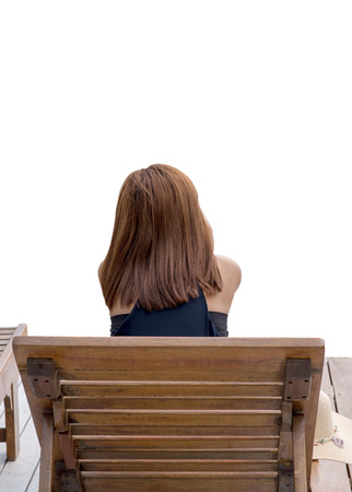 Woman sitting on a wooden stool in natural background sea.の写真素材