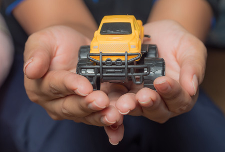 The colour yellow toy car ngonmue women to protect car insurance protection. The concept of waiver of car collisions with posture, prevention and protection of the car icon, car, concept, new truck business gifts.の写真素材
