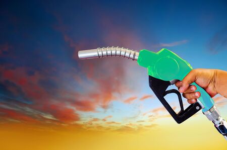 Holding a fuel nozzle against the filling nozzle a hand in his hand that separates from the...